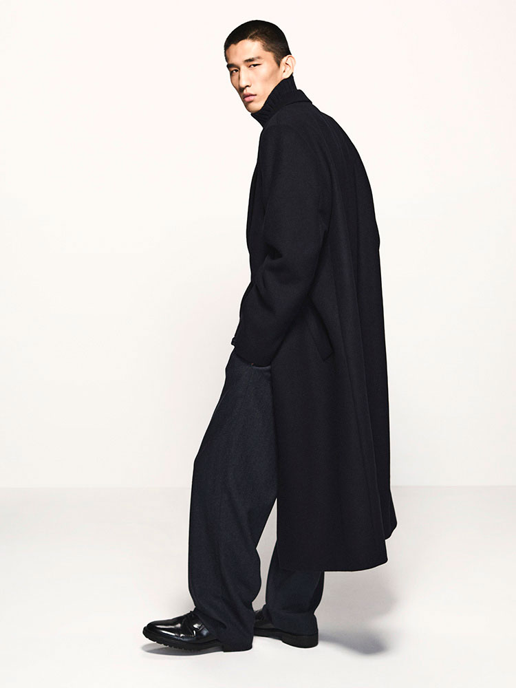 man wearing turtleneck standing on balcony